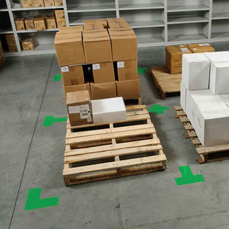 Warehouse pallet area clearly marked with green floor tape corners, demonstrating 5S visual control and organization