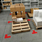 Warehouse pallet storage area marked with red floor tape corners for 5S visual organization and safety awareness